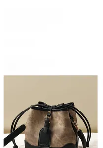 Gros plan du sac seau vintage en tissu marron avec une boucle en métal doré chic