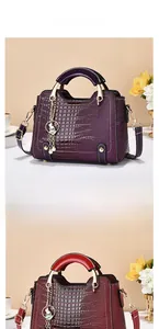 Detail view of crocodile texture handbags in purple and red with rabbit metal charms