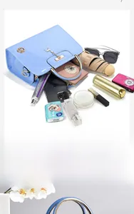 Interior storage capacity of a light blue quilted patent leather handbag with accessories