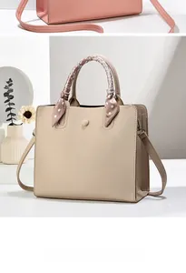 Détail du sac cabas beige motif litchi avec poignée décorée d'un foulard en soie à pois