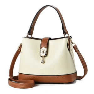 Schicke zweifarbige Beuteltasche in Creme und Braun mit Goldbären-Verschluss und Gurt
