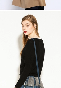 Navy blue leather handbag with gold hardware styled with a black top and silver skirt