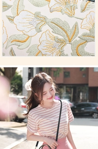 Détail de broderie florale sur un sac à main blanc avec vue portée par un mannequin