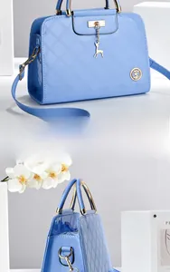 Close-up of sky blue patent leather handbag with diamond quilting and deer charm