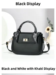 Detail of black faux leather handbag featuring a silk scarf handle and gold rotary lock