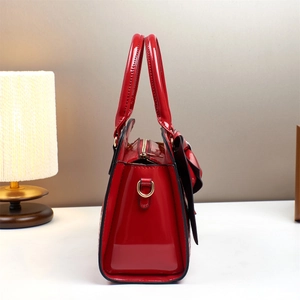 Red patent leather bucket bag with crocodile texture and gold hardware details