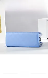 Detailed bottom view of sky blue quilted patent leather handbag with precise stitching
