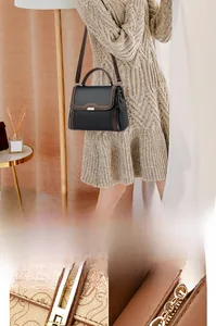 Detailed macro view of high-quality metal hardware and textured stitching on black handbag