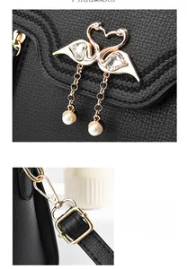 Close-up of golden twin swan hardware with crystal inlays and pearls on black litchi leather