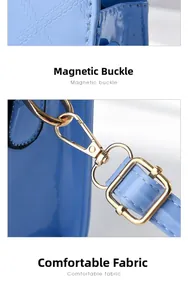 Detail of light blue patent leather bag with quilted pattern and gold metal buckles