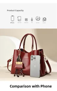 Détail du sac cabas en cuir bordeaux avec ferrures dorées et un mini charme assorti