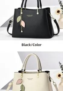 Detail view of lychee grain leather tote bags with leaf charms and gold fashion text