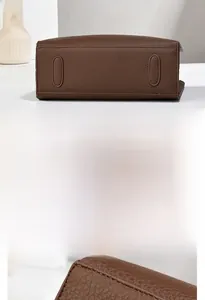 Vue détaillée du cuir grainé marron foncé et des surpiqûres sur le fond du sac