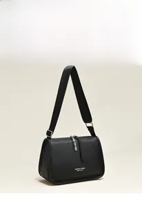 Detail of black lychee grain leather crossbody bag with nylon strap and silver hardware