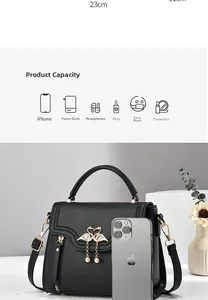 Detail of black pebbled leather crossbody bag with swan hardware and pearl charm