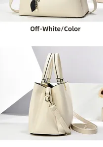 Detailed view of beige pebble leather handbag with gold hardware and pearl leaf charm
