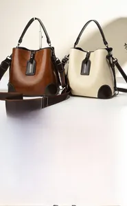 Detailed view of dual-color bucket handbags with silk scarf and leather texture finish