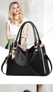 Close-up of black lychee texture handbag with golden cat pendant and tassel detail