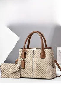Close-up of a beige patterned tote bag with a matching envelope wallet and leather handles