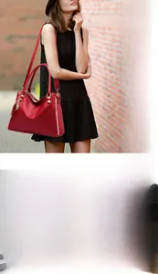 Detail of red pebbled leather tote bag with gold hardware and removable shoulder strap