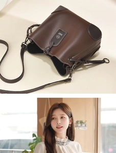 Detail of brown litchi pattern leather bucket bag with MMF brand tag and wide strap
