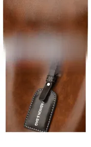 Detail of soft brown pebble leather texture with a decorative fashion tag on a handbag