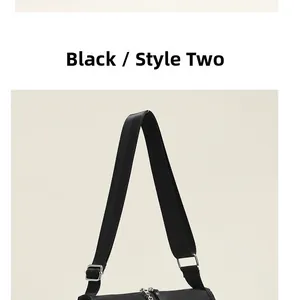 Close-up of black crossbody bag detail with adjustable wide strap and silver hardware