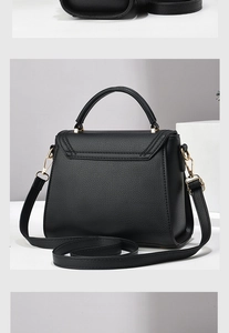 Detailed view of black litchi grain leather texture and gold hardware on small tote bag