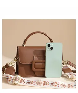 Borsa a tracolla in pelle PU marrone confrontata con uno smartphone per dimensioni