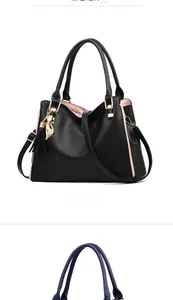 Detail of black pebbled leather tote bag with pink lining and golden cat tassel charm