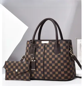 Close-up of checkered pattern tote bag with gold hardware and brown leather handles
