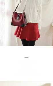 Detail of wine red leather bucket bag with black trim and fashion hangtag
