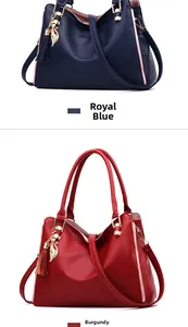 Detail of royal blue and wine red leather bags with cat pendant and gold hardware