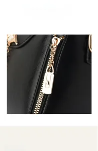 Detailed macro view of high-quality golden metal zipper on a black vintage leather handbag