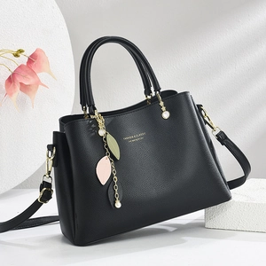 Elegant black lychee leather handbag with leaf charms and adjustable shoulder strap