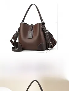 Detail view of coffee leather bucket bag with dimensions and striped shoulder strap