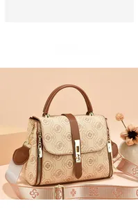 Detail of beige crossbody bag with vintage floral print and brown leather handles