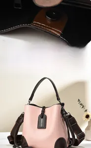 Detail of pink and brown leather bucket bag with magnetic closure and fashion tag