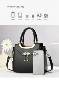 Detail showing high capacity of black faux leather handbag with pearl charm and gold hardware