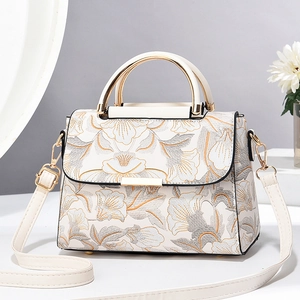 Sac à main blanc élégant avec broderies florales dorées et poignée métallique