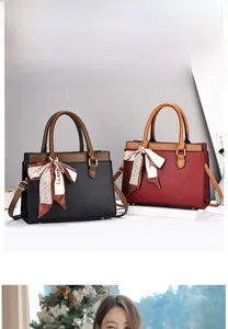 Close-up of litchi grain texture on black and burgundy tote bags with silk scarf details