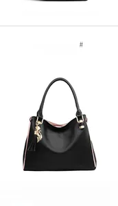 Detail of black pebbled leather tote bag with pink lining and golden cat charm