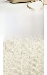 Macro detail of checkerboard textured beige leather on a modern crossbody handbag