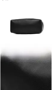 Detail shot of black litchi texture faux leather handbag showing stitching and base