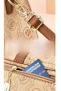 Detail of vintage brown shoulder bag showing gold metal buckle and interior zipper pocket
