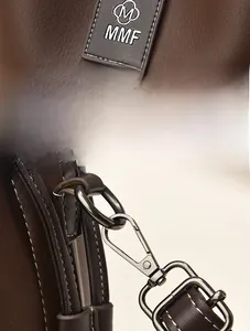 Close-up of brown bucket bag featuring MMF logo tag and gunmetal hardware details