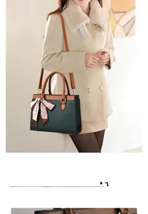 Deep green lychee textured handbag with brown straps and a decorative floral silk scarf