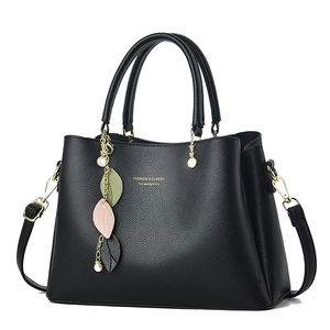 Classic black pebbled leather handbag with gold leaf pendant and detachable strap