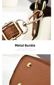 Detailed close-up of golden hardware hooks and anti-wear studs on leather handbag