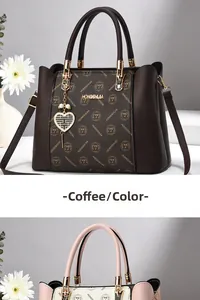 Détail du sac à main imprimé café avec breloque cœur et poignée supérieure contrastée